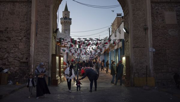 الناس بالقرب من أحد مداخل المدينة القديمة في طرابلس في ليبيا - سبوتنيك عربي