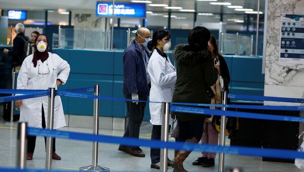 فريق طبي تونسي يوزع أوراق المعلومات عند وصول الركاب إلى مطار تونس بعد فحصهم بواسطة الماسحات الضوئية الحرارية لمعرفة أعراض فيروس كورونا - سبوتنيك عربي