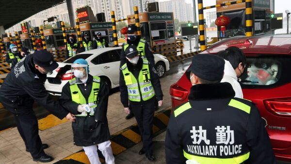 ضباط صينيون يفحصون سيارة بعد انتشار فيروس كورونا - سبوتنيك عربي