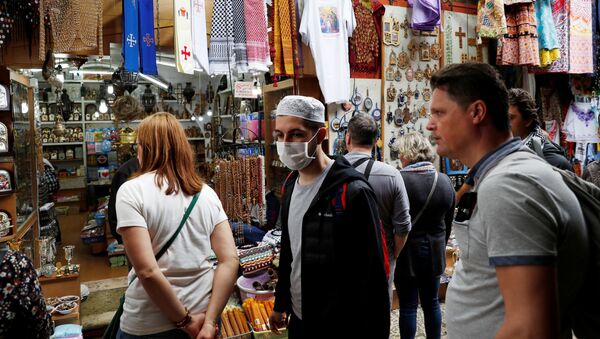 شخص يرتدي كمامة واقية من فيروس كروونا (كوفيد-19) بينما يسير في مدينة القدس - سبوتنيك عربي