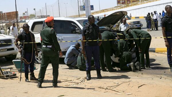 أفراد الأمن يقفون بالقرب من سيارة تضررت إثر انفجار استهدف موكب رئيس الوزراء السوداني عبد الله حمدوك بالقرب من جسر كوبر بالخرطوم - سبوتنيك عربي