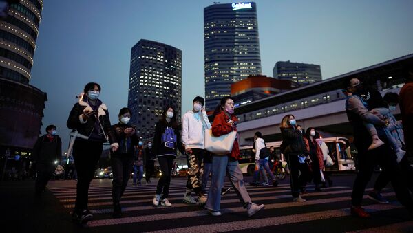 أناس يرتدون كمامات واقية من فيروس كورونا المستجد المسبب لمرض (كوفيد-19) في مدينة شنغهاي الصينية - سبوتنيك عربي