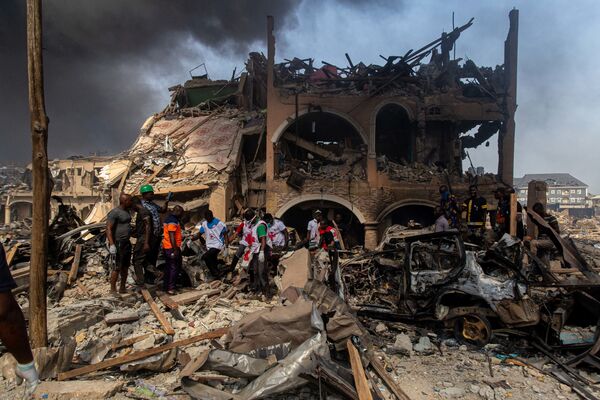 أعضاء من الصليب الأحمر يخرجون جثة من ركام المنزل، بعد أن دمره انفجار غاز وأدى إلى مقتل 15 شخصًا على الأقل، في العاصمة التجارية لنيجيريا لاغوس ودمرت حوالي 50 مبنى في 15 مارس 2020. - سبوتنيك عربي