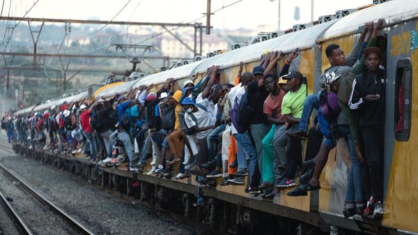 ركاب يمسكون بالقطار ركاب مكتظ في سويتو، جنوب أفريقيا، 16 مارس 2020. - سبوتنيك عربي