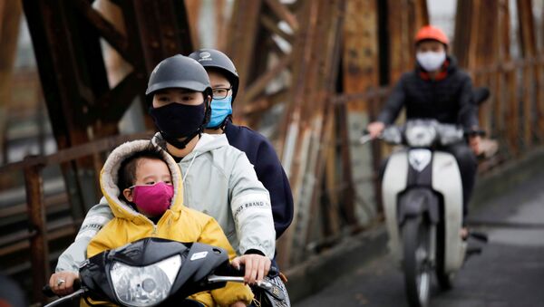 يرتدي الناس أقنعة واقية للوجه لحماية أنفسهم من فيروس كورونا التاجي في هانوي في فيتنام - سبوتنيك عربي