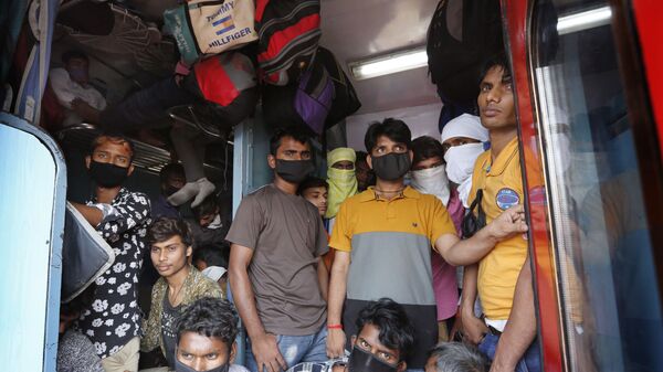 عاملون بأجر يومي يعودون من مومباي إلى قراهم وسط مخاوف من فيروس كورونا في حافلة قطار مزدحمة في براياغراج في الهند - سبوتنيك عربي
