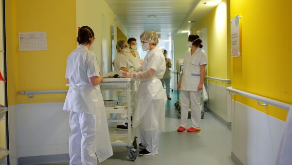 عمال طبيون يرتدون أقنعة واقية يرتدون بدلات في قسم أمراض الرئة في مستشفى فانيه في فرنسا حيث يعاني المرضى من مرض فيروس التاجي (COVID-19) - سبوتنيك عربي
