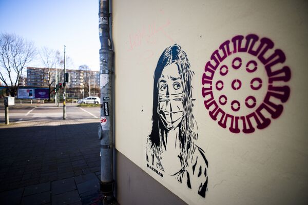 رسم غرافيتي لفتاة ترتدي قناعا واقيا بجوار صورة توضيحية لفيروس كورونا المستجد، برلين، ألمانيا 14 فبراير 2020 - سبوتنيك عربي