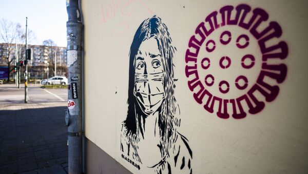 رسم غرافيتي لفتاة ترتدي قناعا واقيا بجوار صورة توضيحية لفيروس كورونا المستجد، برلين، ألمانيا 14 فبراير 2020 - سبوتنيك عربي