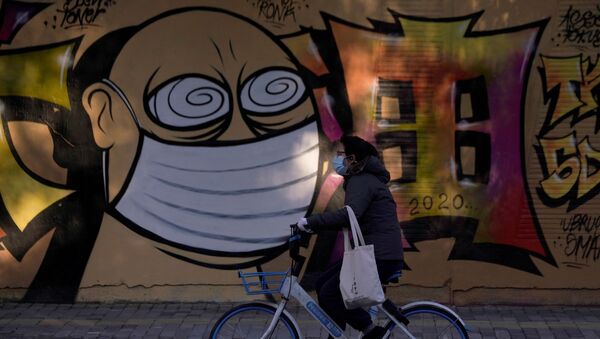 امرأة ترتدي قناعا واقيا تسير على خلفية رسم غرافيتي لشخص يرتدي قناعا واقيا، شنغهاي، الصين 17 فبراير 2020 - سبوتنيك عربي