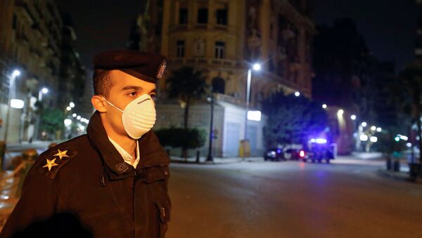 ضابط مصري يرتدي كمامة واقية من فيروس كورونا في أثناء تنفيذ حظر التجوال في البلاد - سبوتنيك عربي