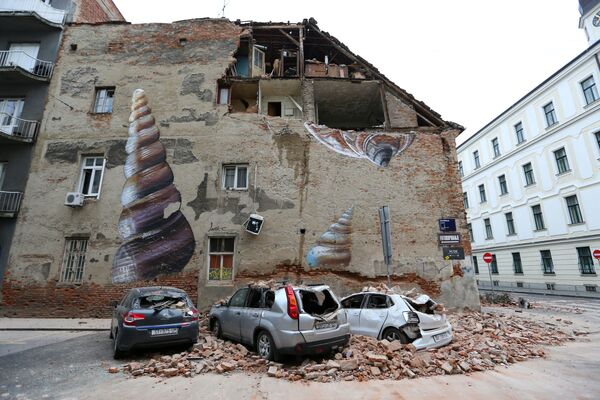 السيارات المتضررة والمبنى المتضرر جزئيًا بعد زلزال قوي ضرب مدينة زغرب، كرواتيا 22 مارس 2020 - سبوتنيك عربي