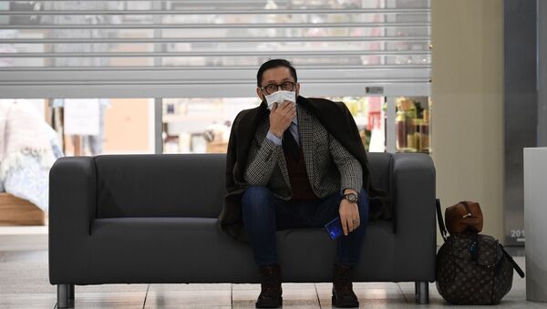 رجل يرتدي قناع الوجه الواقي يجلس على أريكة في مركز للتسوق في مدينة نوفوسيبيرسك في سيبيريا في روسيا - سبوتنيك عربي