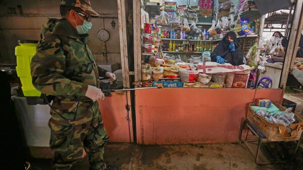 ضابط الدفاع المدني العراقي يقوم بتطهير الأماكن التجارية في ضواحي بغداد، في ظل انتشار فيروس كورونا في العراق 28  مارس 2020 - سبوتنيك عربي
