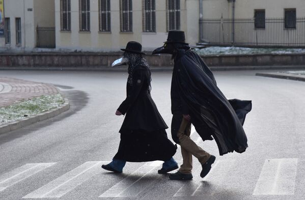 أشخاص يرتدون أقنعة طبيب الطاعون في لفيف وسط تفشي مرض فيروس التاجي كورونا، أوكرانيا 22 مارس 2020 - سبوتنيك عربي