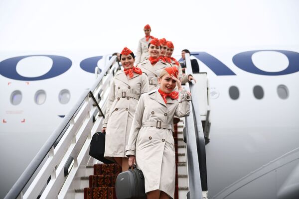 مضيفات الطيران ينزلن سلم طائرة الركاب المخصصة للرحلات طويلة المدى أيرباص A350-900 التابعة لشركة الطيران آيروفلوت الروسية، 4 مارس 2020 - سبوتنيك عربي