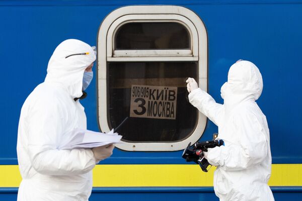 أطباء يرتدون زيا واقيا في قطار خاص رقم 906/905 كييف - موسكو - كييف، الذين وصلوا إلى محطة السكة الحديدية في مدينة كييف، لفحص المواطنين القادمين من موسكو بسبب فيروس كورونا،أوكرانيا،  29 مارس 2020 - سبوتنيك عربي