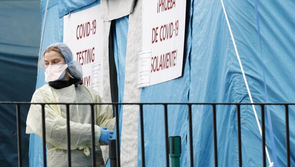 عاملة طبية تستعد لدخول خيمة اختبار COVID-19 التي أقيمت خارج مركز مستشفى إلمهورست في نيويورك - سبوتنيك عربي