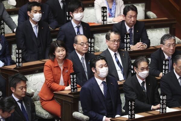 يحضر المشرعون، وبعضهم يرتدون قناع الوجه، جلسة عامة في مجلس النواب في طوكيو، اليابان 12 مارس 2020 - سبوتنيك عربي