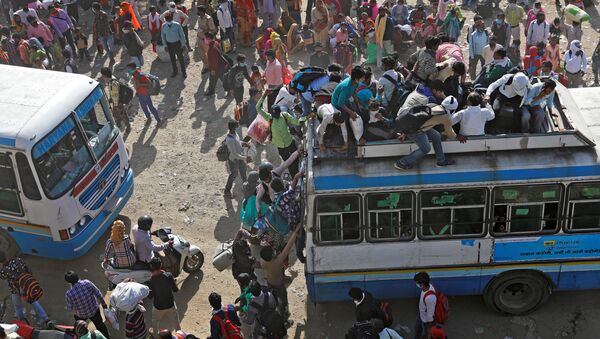 عمال مهاجرون في حافلات مزدحمة في غازي آباد، يحاولون العودة إلى منازلهم، بعد الإعلان عن الإغلاق التام بسبب انتشار فيروس كورونا في الهند 29 مارس 2020 - سبوتنيك عربي