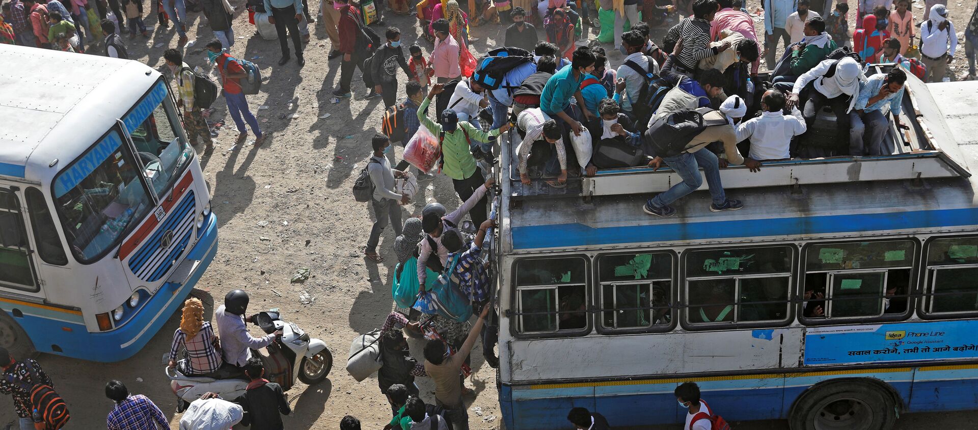عمال مهاجرون في حافلات مزدحمة في غازي آباد، يحاولون العودة إلى منازلهم، بعد الإعلان عن الإغلاق التام بسبب انتشار فيروس كورونا في الهند 29 مارس 2020 - سبوتنيك عربي, 1920, 16.05.2020