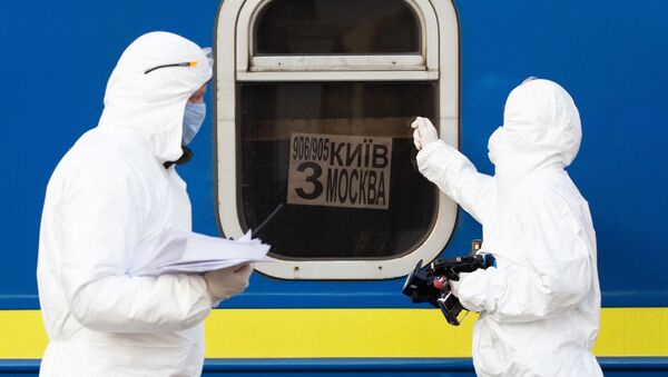 أطباء يرتدون زيا واقيا في قطار خاص رقم 906/905 كييف - موسكو - كييف، الذين وصلوا إلى محطة السكة الحديدية في مدينة كييف، لفحص المواطنين القادمين من موسكو بسبب فيروس كورونا،أوكرانيا،  29 مارس 2020 - سبوتنيك عربي