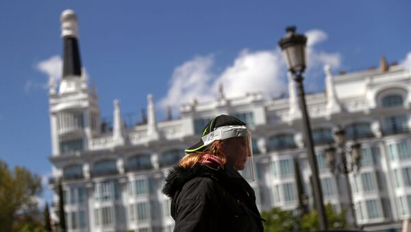 امرأة ترتدي قناعا واقيا وتسير في شوارع مدريد - سبوتنيك عربي