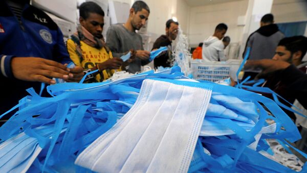 عمال في مصنع ينتج معدات جراحية معقمة وملابس طبية في حين تكثف مصر جهودها لإبطاء انتشار فيروس كورونا - سبوتنيك عربي