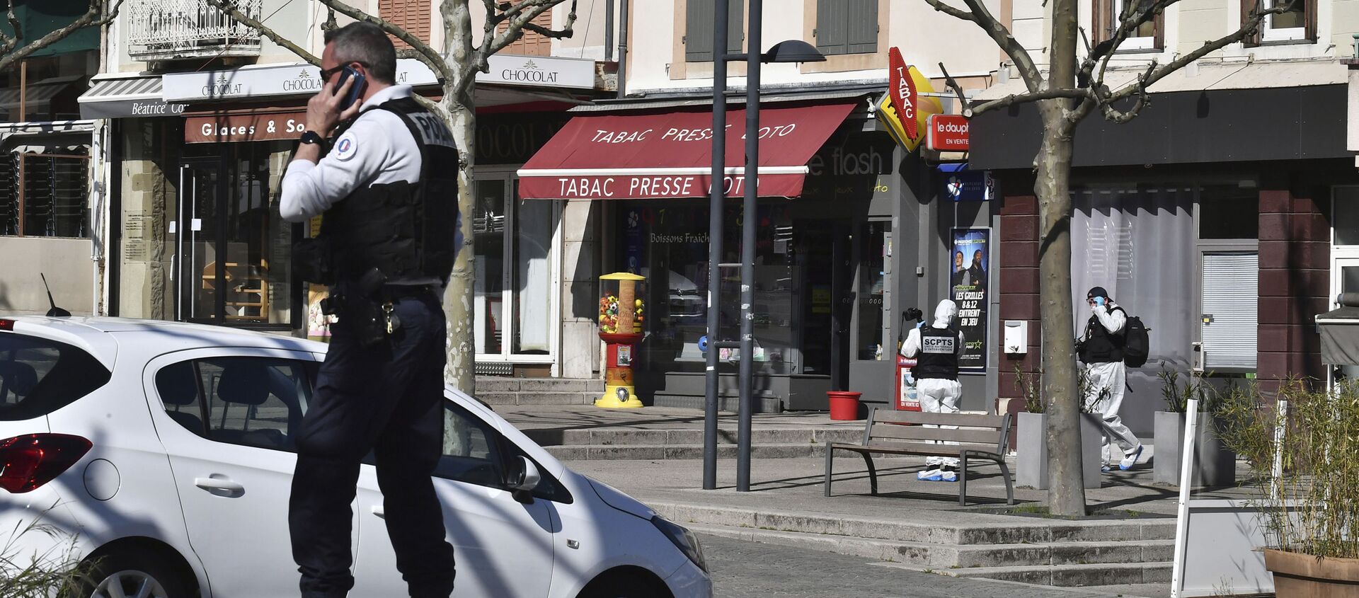 ضابط شرطة يجري مكالمة هاتفية بعد أن هاجم رجل يحمل سكينًا السكان الذين يغامرون بالتسوق في بلدة رومان سور إيزير تحت الإغلاق جنوب فرنسا - سبوتنيك عربي, 1920, 04.05.2020