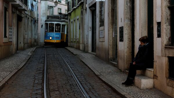 امرأة تنتظر الترام في حي ألفاما بعد تفشي فيروس كورونا في لشبونة في البرتغال - سبوتنيك عربي