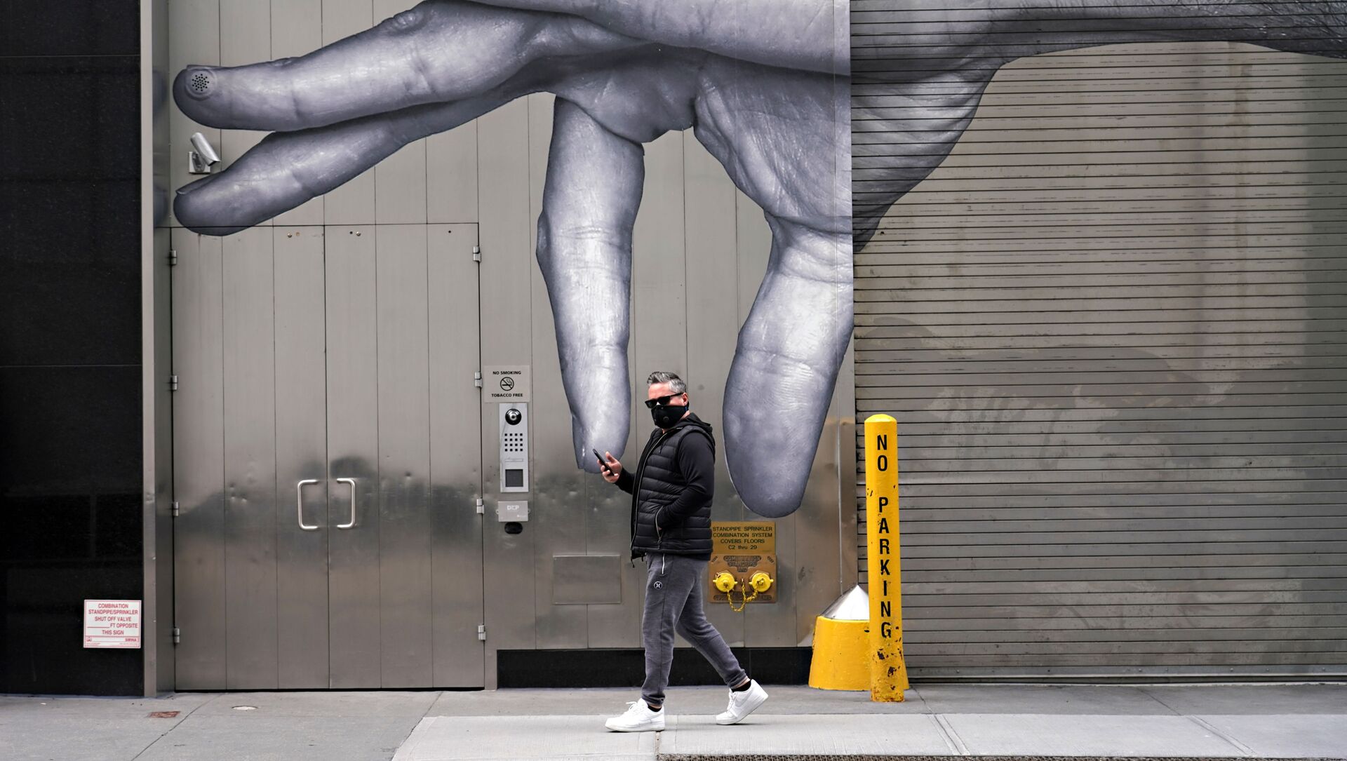 رجل يرتدي قناعاً واقياً يسير بجوار فن الشارع وسط انتشار الجائحة، فيروس كورونا في مدينة نيويورك، 5 أبريل 2020 - سبوتنيك عربي, 1920, 26.04.2021
