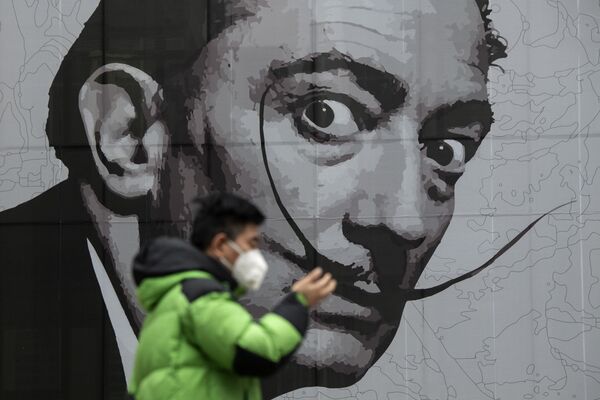 رجل يرتدي القناع الواقي يسير على خلفية جدارية في مركز تجاري في شنغهاي، الصين 7 فبراير 2020 - سبوتنيك عربي
