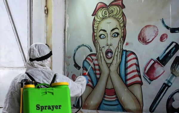 متطوع يقوم بتطهير متجر في حي البياع ببغداد، يوم 21 مارس 2020 ، كإجراء وقائي ضد انتشار الفيروس التاجي كوفيد-19، العراق - سبوتنيك عربي