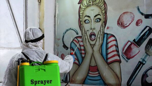 متطوع يقوم بتطهير متجر في حي البياع ببغداد، يوم 21 مارس 2020 ، كإجراء وقائي ضد انتشار الفيروس التاجي كوفيد-19، العراق - سبوتنيك عربي