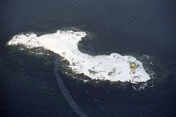 جزيرة بها منارة في بحر بارنتس خارج الدائرة القطبية الشمالية. صورة التقطت من مروحية أسطول الشمال الروسية - سبوتنيك عربي