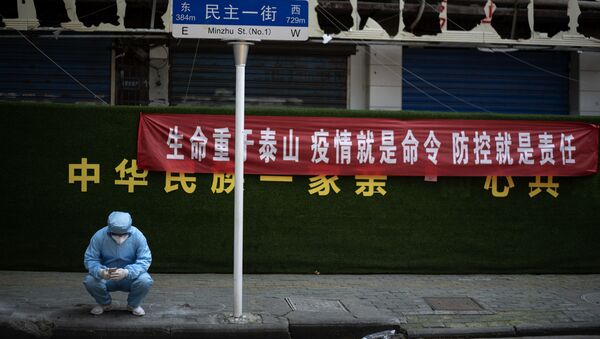 يستخدم رجل يرتدي بدلة حماية في ووهان بمقاطعة هوبي وسط الصين - سبوتنيك عربي
