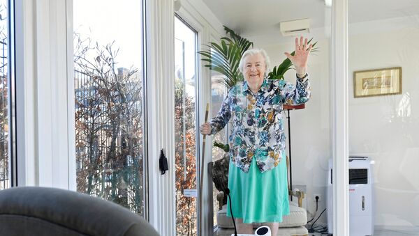 امرأة في مركز رعاية المسنين المصابين بالخرف في منزل زجاجي مصنوع بشكل خاص ضد الشعور بالوحدة بسبب حظر الزيارة بسبب مرض فيروس كورونا في فاسينار في هولندا - سبوتنيك عربي