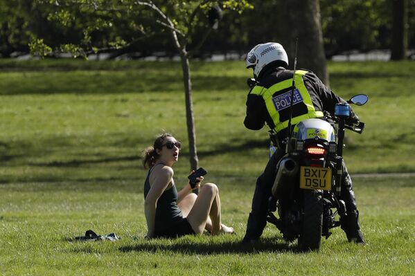 شرطي يطلب من فتاة مغادرة الحديقة، في ظل الإجراءات التقييدية خلال وباء الفيروس التاجي كورونا في لندن، بريطانيا 5 أبريل 2020 - سبوتنيك عربي