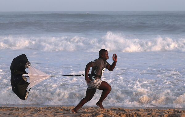 رياضي خلال دورة تدريبية على شاطئ ريسيريو دوس بانديرانتيس بيتش في ريو دي جانيرو، البرازيل 4 أبريل 2020 - سبوتنيك عربي