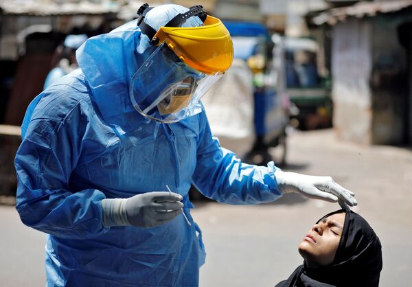 طبيب يرتدي بدلة واقية يفحص فتاة، تحاليل فيروس كورونا، في أحمد آباد، الهند 8 أبريل 2020 - سبوتنيك عربي