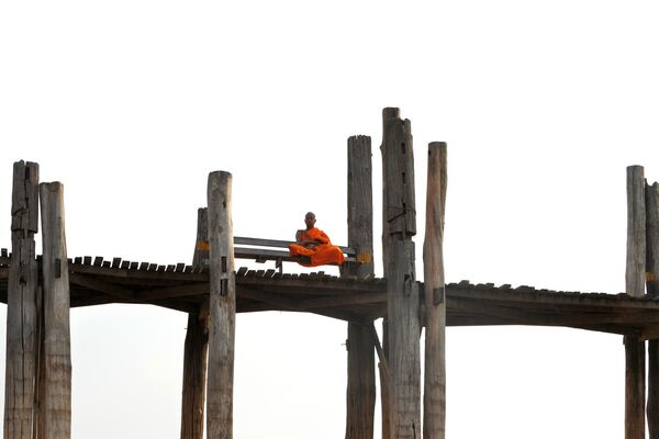راهب يجلس على جسر يو بين في ماندالاي، ميانمار 4 أبريل 2020 - سبوتنيك عربي