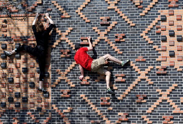 المتسلقان كارلوتا ورفاييل يتدربان على جدار منزل في منطقة هافنسيتي، مع استمرار انتشار مرض الفيروس التاجي (كوفيد-19) في هامبورغ، ألمانيا 5 أبريل 2020 - سبوتنيك عربي