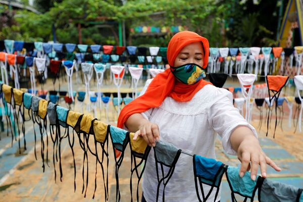 امرأة تحضر الأقنعة الواقية قبل توزيعها مجانًا في الحي، وسط انتشار مرض فيروس كورونا (كوفيد-19) في تانجيرانج، على مشارف جاكرتا، إندونيسيا 9 أبريل 2020 - سبوتنيك عربي