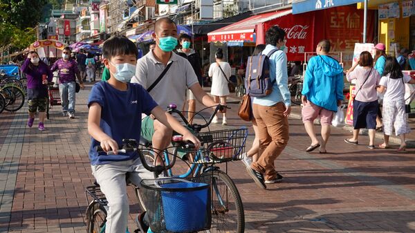 أشخاص يرتدون أقنعة الوجه في جزيرة تشيونغ تشاو خلال عطلة عيد الفصح وسط انتشار مرض فيروس كورونا في هونغ كونغ - سبوتنيك عربي