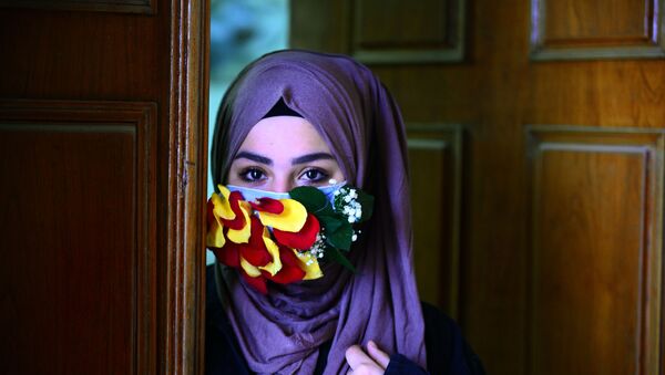 فتاة ترتدي قناعا للوقاية من عدوى فيروس كورونا في النجف، العراق  21 مارس 2020 - سبوتنيك عربي