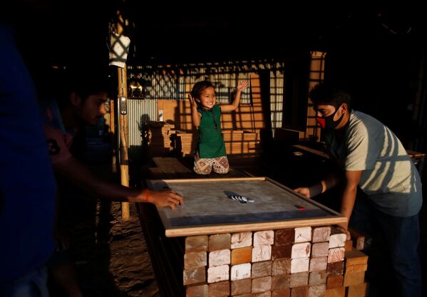 عائلة تلعب لعبة كارم (كاروم) في لاليتبور، نيبال 2 أبريل 2020 - سبوتنيك عربي