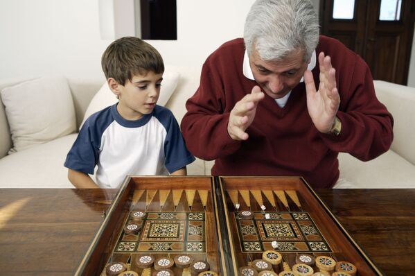جد يلعب مع حفيده لعبة الطاولة (أو النَّرد) - سبوتنيك عربي