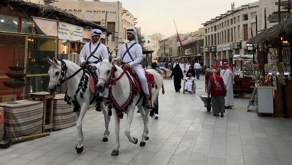 رجال يرتدون الأزياء التقليدية يركبون الخيول في سوق واقف بعد تفشي فيروس كورونا في الدوحة - سبوتنيك عربي