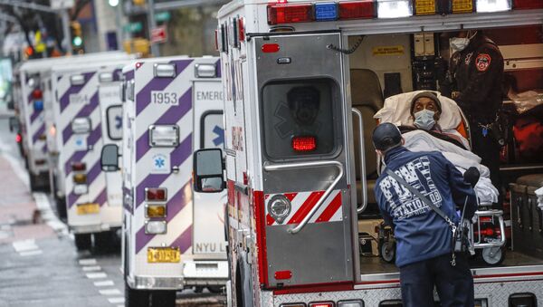 مريض يصل بسيارة إسعاف برعاية عاملين طبيين يرتدون معدات وقائية بسبب مخاوف كوفيد-19  خارج مركز جامعة نيويورك لانغون الطبي، 13 أبريل 2020 ، في نيويورك، الولايات المتحدة - سبوتنيك عربي
