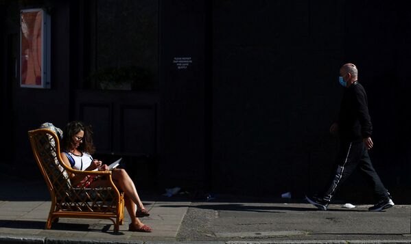 امرأة تجلس في الخارج في  حي داتسون، على خلفية انتشار مرض فيروس كورونا (كوفيد-19)، لندن، بريطانيا، 14 أبريل 2020. - سبوتنيك عربي